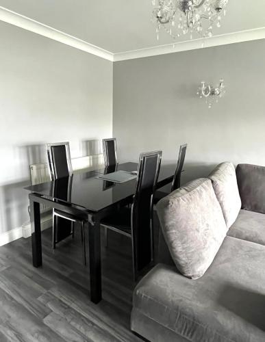 a dining room with a table and a couch at Modern Stylish Two Bedroom Apartment in Beckenham