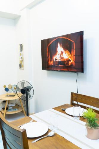 a dining room table with a fireplace on the wall at Condotel Northpoint 2 Bedroom 1 bathroom in Davao City