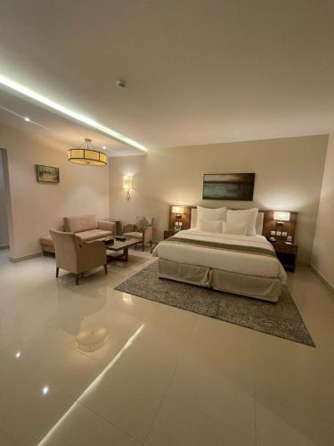 a bedroom with a bed and a living room at Best Western Plus Buraidah in Buraydah