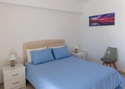 a bedroom with a blue bed and two night stands at Larnaca BeachHouse in Larnaka