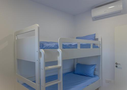 a bunk bed room with two bunk beds and blue pillows at Larnaca BeachHouse in Larnaka