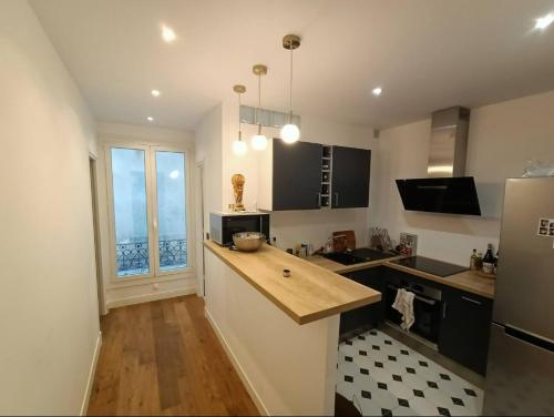 une cuisine avec un comptoir et une grande fenêtre dans l'établissement Brand new flat - Really calm in Central Paris, à Paris