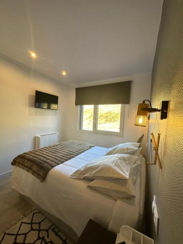 a bedroom with a large white bed with a window at Sapporo, a pie de pistas! in Pas de la Casa