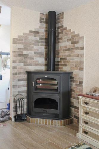a brick fireplace with a stove in a room at Casa Mary R&R in Albolodúy