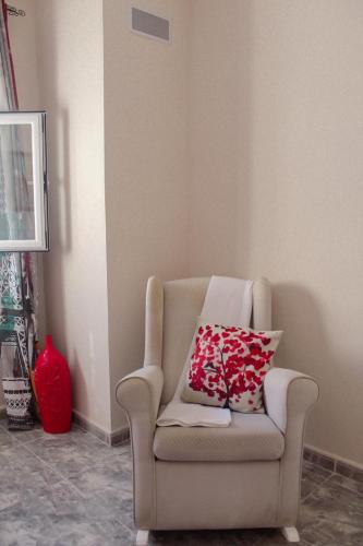 a chair with two pillows on it in a room at Casa Mary R&R in Albolodúy