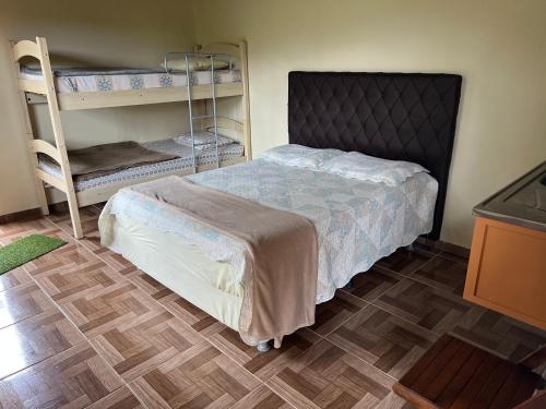 a bedroom with a bed and bunk beds at Casa nas montanhas com piscina e vista panorâmica in Domingos Martins