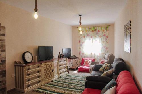 a living room with a couch and a tv at Casa Mary R&R in Albolodúy
