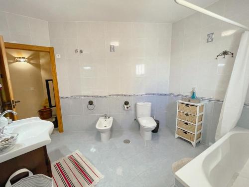 a white bathroom with a toilet and a sink at Casa Rural Alboloduy R&R 