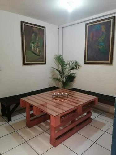 a wooden coffee table in a room with paintings at céntrico confort y paz in San Francisco dos Rios