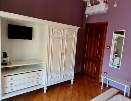 a white cabinet in a room with a mirror at V.home in Abano Terme