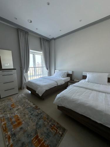 a large bedroom with two beds and a television at Kama Place in Muscat
