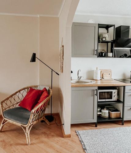 a living room with a chair and a kitchen at Rauna Apartment NR 8 in Rauna