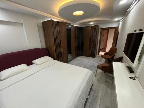 Istanbul Apartments في إسطنبول: غرفة نوم بسرير ابيض وتلفزيون