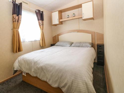 1 dormitorio con 1 cama grande y ventana en 18 Chestnut Gardens, en Rhyl