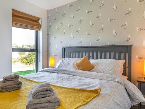 a bedroom with a bed and a wall with seagulls at Shearwater Lodge in Bamburgh