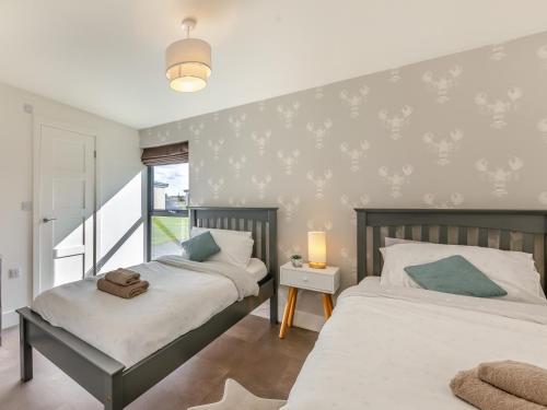 a bedroom with two beds and a window at Shearwater Lodge in Bamburgh