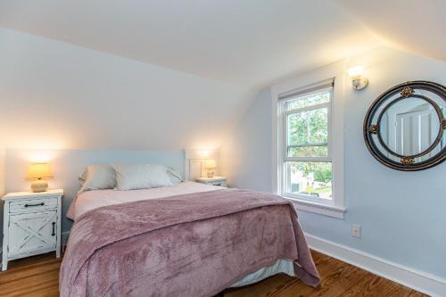 Schlafzimmer mit einem Bett und einem Wandspiegel in der Unterkunft Hill & Harbor Cove House in East Greenwich