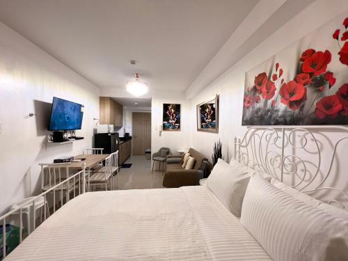 a bedroom with a white bed and a living room at Studio Units at Shore Residences Condo MOA Complex near Airport in Manila
