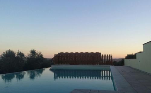 a swimming pool with two chairs next to a building at Agriturismo San Lorenzo in Lastra a Signa