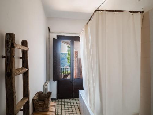 a bathroom with a black door and a white shower curtain at Masovería Ca la Maria in Arbúcies