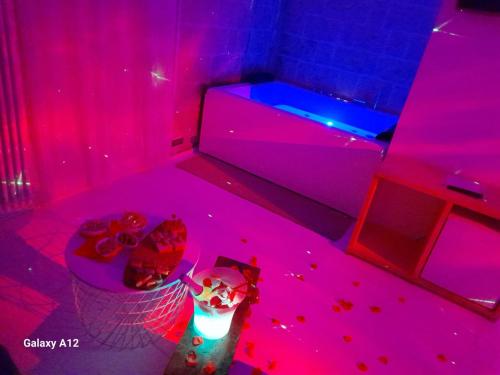 a room with pink and blue lights and a tub at Recinto antico Sweet Rooms in Matera