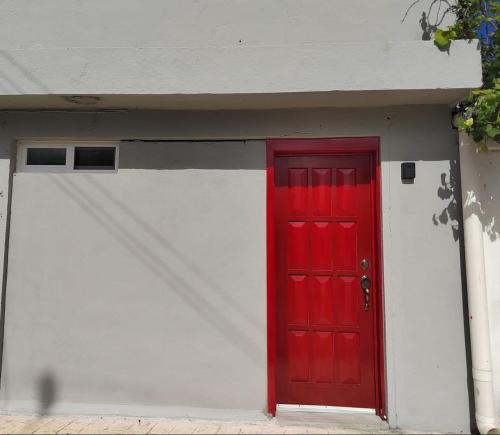 una porta rossa su un garage bianco con una porta rossa di 10th ave Suite a Cozumel