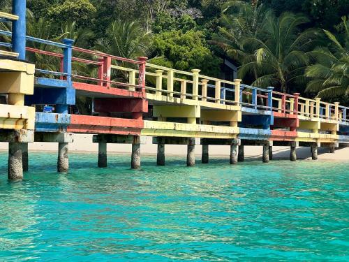 un molo colorato sull'acqua vicino a una spiaggia di Perhentian Suria a Isole Perhentian