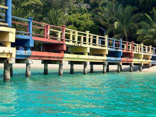 a colorful pier on the water next to a beach at Perhentian Suria in Perhentian Islands