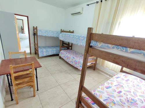 Habitación con 3 literas, mesa y escritorio. en Hostel Dela, en Tiradentes