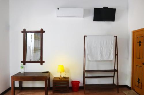 Habitación con espejo y mesa con lámpara. en Flying Peacock Yala, Katharagama,, en Kataragama