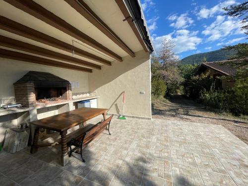un patio con una mesa de madera y un horno de pizza en Casa Rural Uría - Ubicación perfecta, rodeado de naturaleza, vistas espectaculares, en Gavín