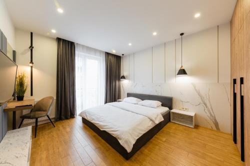 1 dormitorio con cama, escritorio y silla en Luxury Apartments “Bozdosh” en Úzhgorod