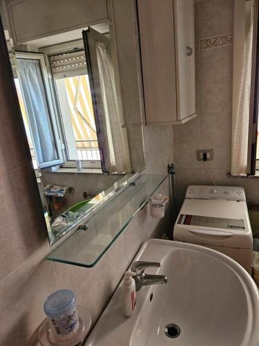 y baño con lavabo, aseo y espejo. en Santa teresa via regina margherita,627, en Santa Teresa di Riva