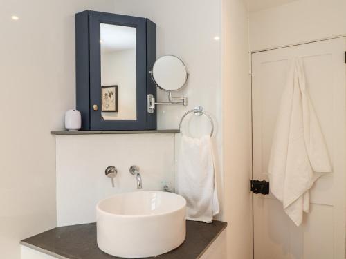 een witte badkamer met een wastafel en een spiegel bij The Old Customs Post in Flushing