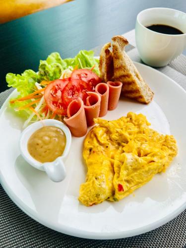 a plate of breakfast food with eggs and toast and a cup of coffee at Farm View Resort @Uthai Thani ฟาร์มวิว รีสอร์ท อุทัยธานี in Nong Khayang