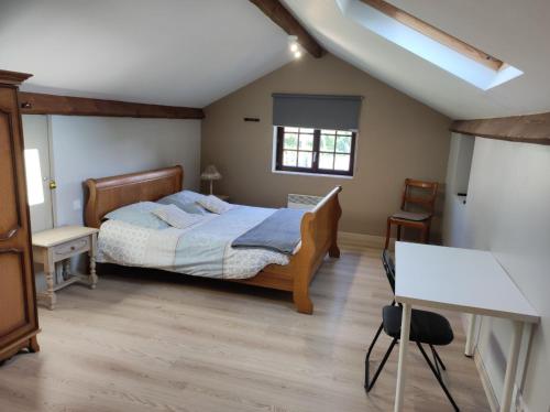 um quarto com uma cama, uma secretária e uma janela em Appartement Gaston em Vireux-Wallerand