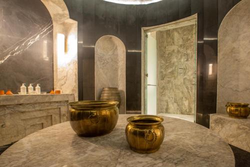 a bathroom with two large gold vases on a table at Fairmont La Marina Rabat Sale Hotel in Rabat