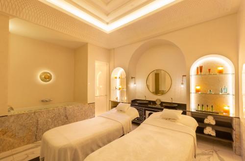 a room with three beds and a mirror at Fairmont La Marina Rabat Sale Hotel in Rabat