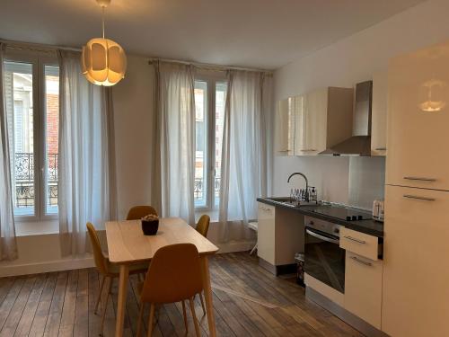 une cuisine et une salle à manger avec une table et des chaises dans l'établissement Les Hortensias, à Épernay