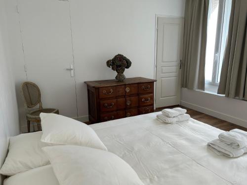 a bedroom with a white bed with towels on it at Les Hortensias in Épernay