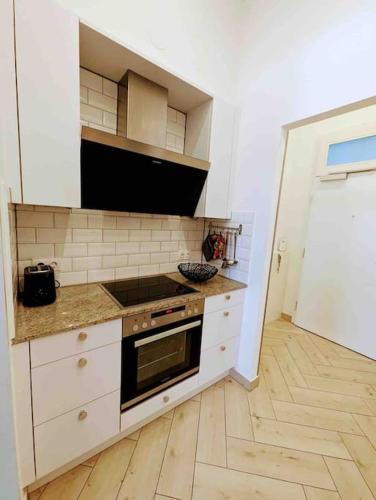 una cucina con mobili bianchi e un forno a piano cottura di Luxury CityApartment 2 a Vienna