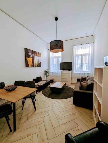 Luxury CityApartment 2 في فيينا: غرفة معيشة كبيرة مع طاولة وكراسي
