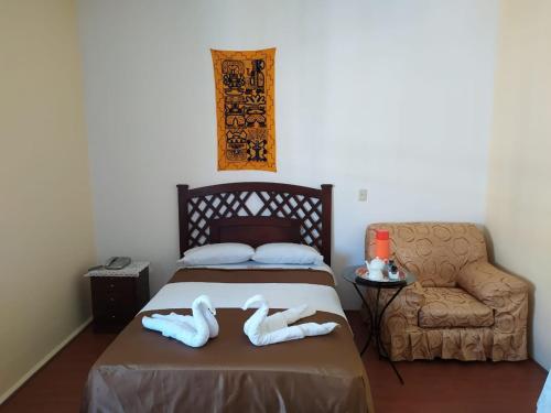 a bedroom with a bed and a chair with towels on it at Hotel La Posada Del Sol in Arequipa