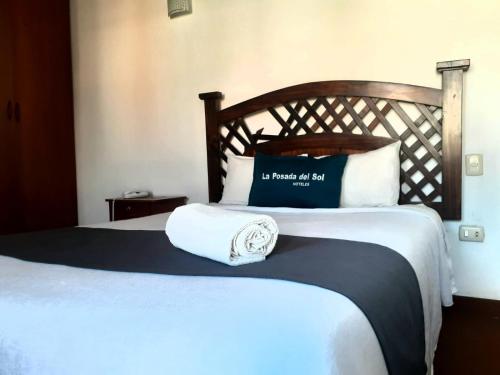 a bedroom with a bed with a blue and white pillow at Hotel La Posada Del Sol in Arequipa