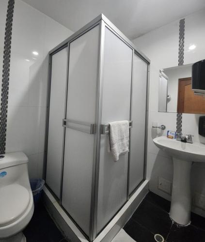 a bathroom with a shower and a toilet and a sink at Hotel Ciudad Capri in Cali
