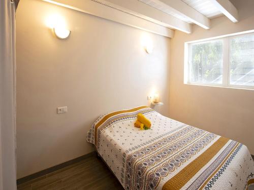 um quarto com uma cama com um objecto amarelo em Villa Pinel em Cul de Sac