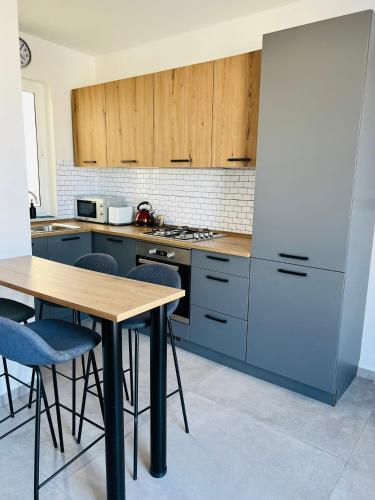 kuchnia z drewnianym stołem i niebieskimi szafkami w obiekcie SinSea Penthouse w mieście St Paul's Bay