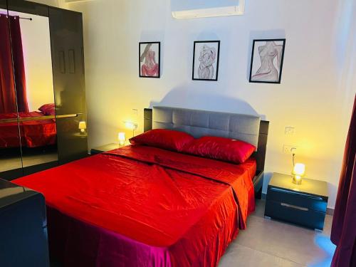 sypialnia z czerwonym łóżkiem i dwiema lampami w obiekcie SinSea Penthouse w mieście St Paul's Bay