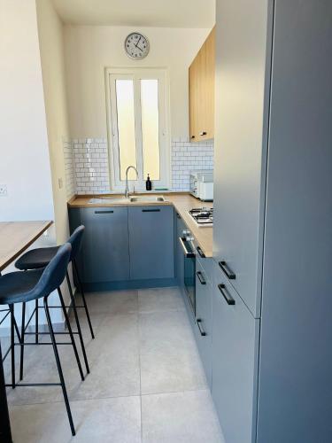 eine Küche mit Kühlschrank und einem Tisch mit Stühlen in der Unterkunft SinSea Penthouse in St Paul's Bay