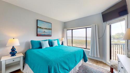 希爾頓頭島的住宿－245 Captains Quarters，一间卧室设有蓝色的床和大窗户
